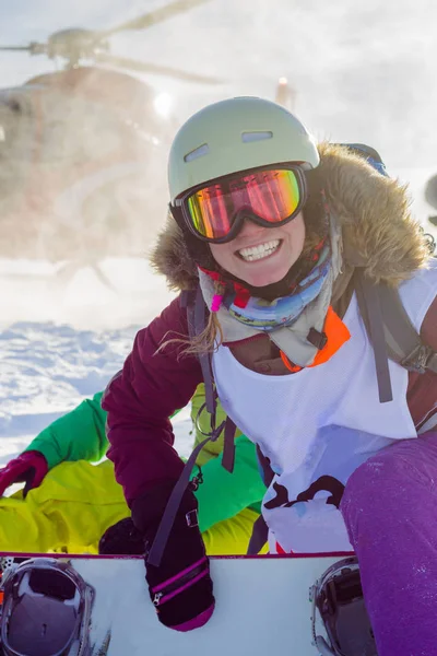 Snowboardåkare tjej freerider lokaliseringen på helikopter i snötäckta berg — Stockfoto