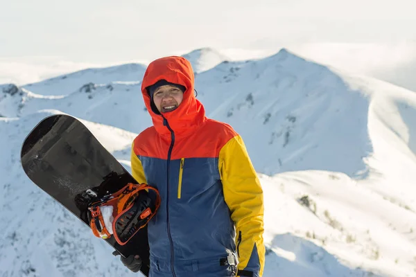 Snowboarder freerider est debout dans les montagnes enneigées en hiver sous les nuages — Photo