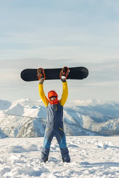 Snowboarder freerider está de pie en las montañas nevadas en invierno bajo las nubes —  Fotos de Stock