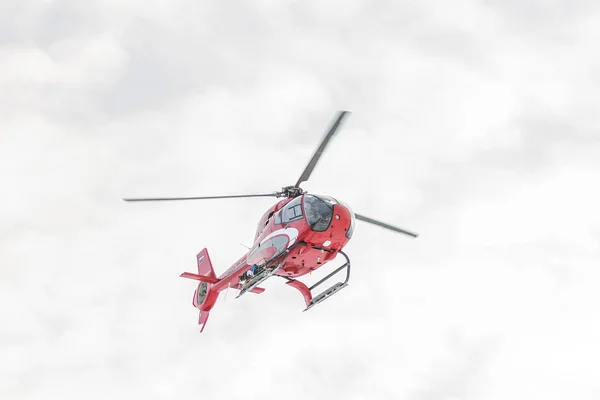 Röd rescue helikopter flyga i snötäckta berg — Stockfoto