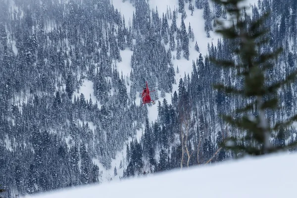 Kırmızı kurtarma helikopteri sinek karlı dağlarda — Stok fotoğraf