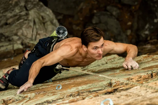 Bergsteiger klettert an einem Seil auf eine Klippe, Blick von oben — Stockfoto