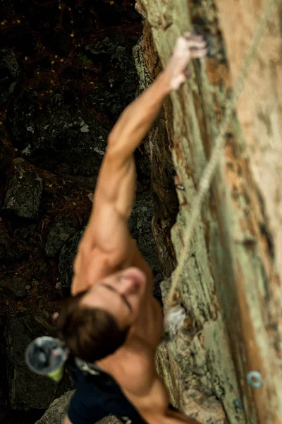 Bergsteiger klettert an einem Seil auf eine Klippe, Blick von oben — Stockfoto