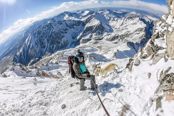 Mann und Hund Labrador wandern durch die wolkenverhangenen Berge — Stockfoto