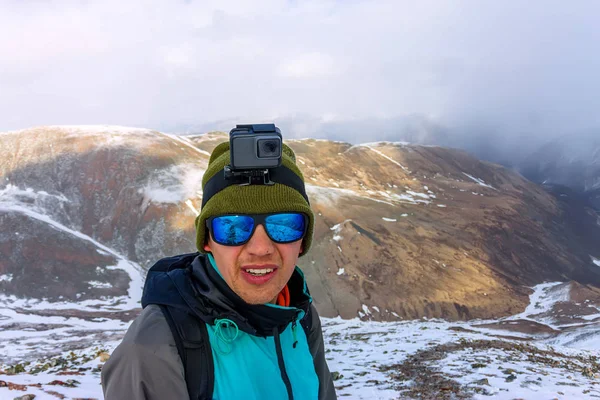 Retrato montañista macho en montañas nevadas, con una mochila — Foto de Stock