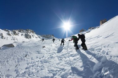 Kar alanı buz baltaları ve kask ile bir iple bağlı olan dağ tırmanma tırmanıcı bağlı