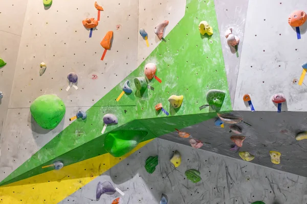 Klimmuur in de hal van de boulder met gekleurde haken — Stockfoto