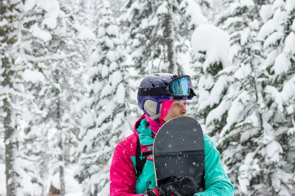 Kvinna freerider snowboardåkare stående i en snöig skog — Stockfoto