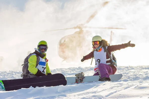 Par de freeriders de snowboarders en tierra helicóptero de fondo —  Fotos de Stock