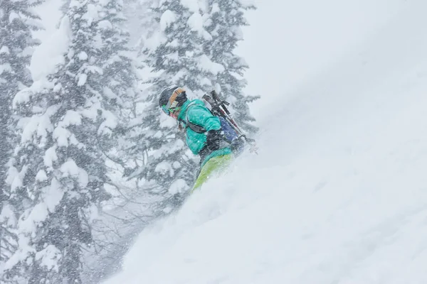 Mulher snowboarder freerider vai para baixo na neve em pó nas montanhas em uma queda de neve — Fotografia de Stock