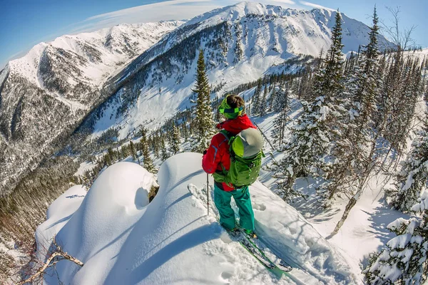 Un hombre parado en la cima de la cresta. Esquí de montaña. Aventura invierno freeride deporte extremo — Foto de Stock