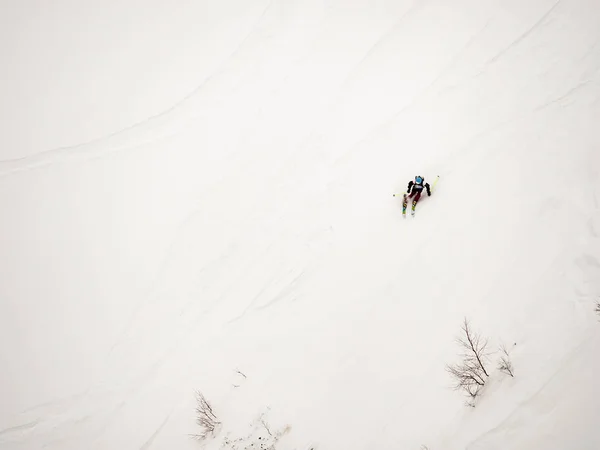 Freerider narciarz opada stromym stoku biały śnieg i drzew w górach Kaukazu — Zdjęcie stockowe