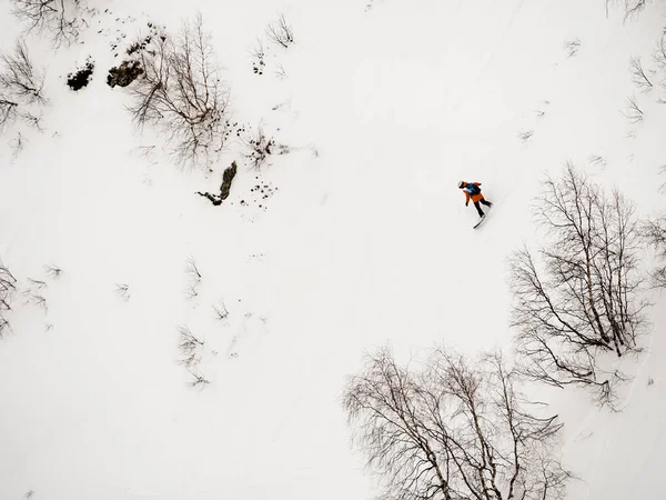 Freerider snowboardzista dół po stromym zboczu, biały śnieg i drzew w górach Kaukazu — Zdjęcie stockowe