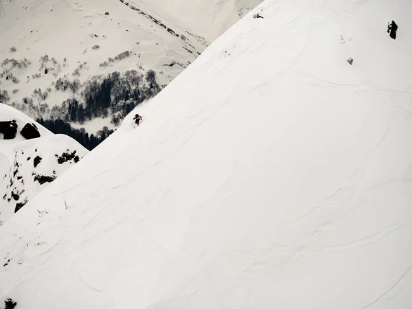 Freerider skiër daalt een steile helling van witte sneeuw en bomen in de bergen van de Kaukasus — Stockfoto