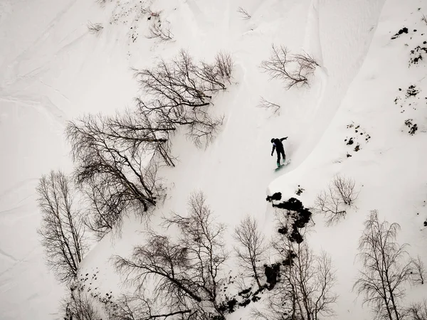 Freerider snowboarder sur la pente raide de la neige blanche et des arbres dans les montagnes du Caucase — Photo