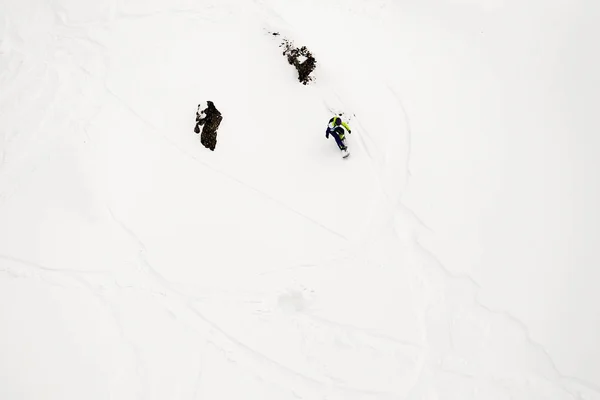 Freerider snowboarder onderaan de steile hellingsgraad van de witte sneeuw en bomen in de bergen van de Kaukasus — Stockfoto