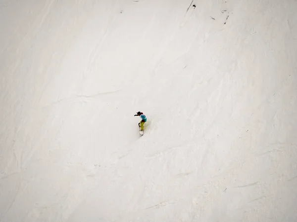 Freerider snowboarder onderaan de steile hellingsgraad van de witte sneeuw en bomen in de bergen van de Kaukasus — Stockfoto