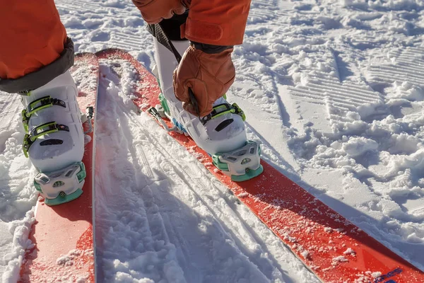 Les jambes d'un skieur freerider se rapprochent sur une piste de velours se préparant pour le ski - fixation des bottes — Photo