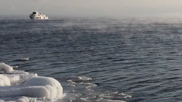 La nave naviga sul lago Baikal galleggiando dal gelo lungo la costa ghiacciata a gennaio — Video Stock