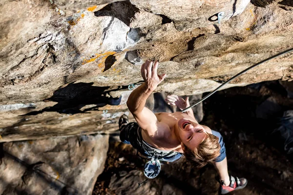 Bergsteiger Mann schreit nach Spannung, hält sich mit einer Hand an einem Felsen fest, Nahaufnahme — Stockfoto