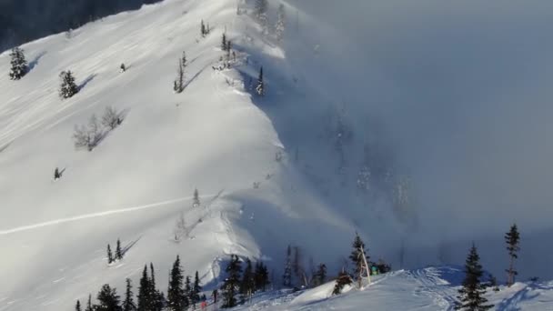 Luchtfoto van drone man skiër skitochten in de besneeuwde bergen omhoog in een lijn — Stockvideo