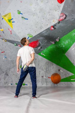 Rock climber erkeği ellerini magnesia toz bir torbaya boulder koridorda arkadan itti