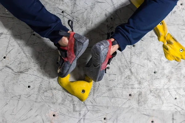 Rocky sko på en liten, torftiga snara står med spetsen på strumpan i närbild på klätterväggen i rummet — Stockfoto