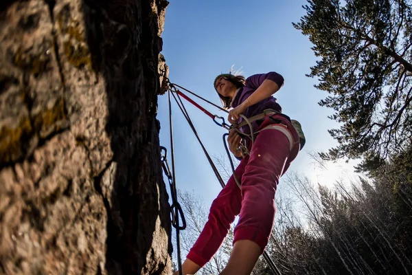 Rock-climber girl crying in pain hanging on a rope with a sad face when climbing on a rock — Stock Photo, Image