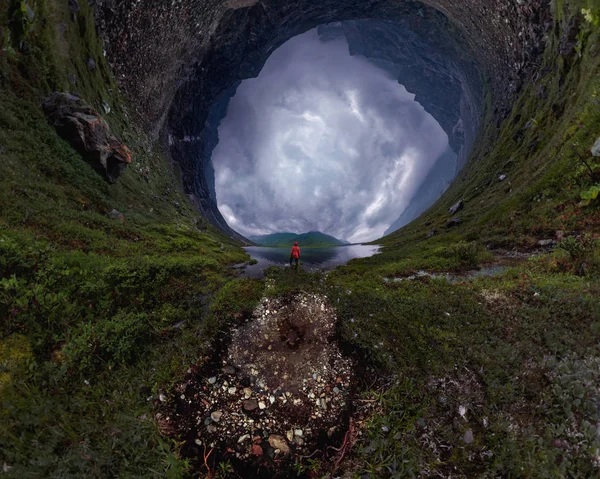 Homem fica junto ao lago em casaco vermelho em tempo nublado. pequeno planeta 360 — Fotografia de Stock
