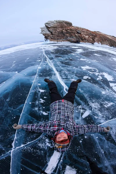Meisje liggend op het ijs op het eiland Ogoy op het Baikalmeer — Stockfoto