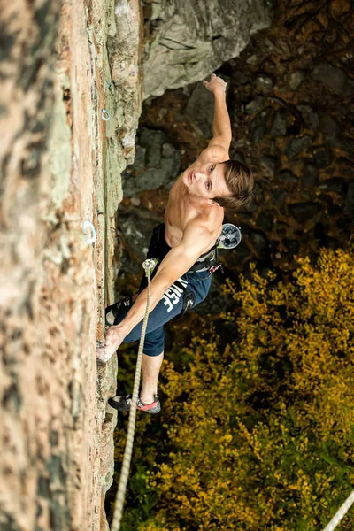 Bergsteiger klettert an einem Seil auf eine Klippe, Blick von oben — Stockfoto