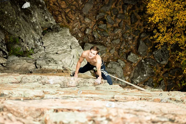 Escalador de roca sube en un acantilado en una cuerda, vista superior —  Fotos de Stock