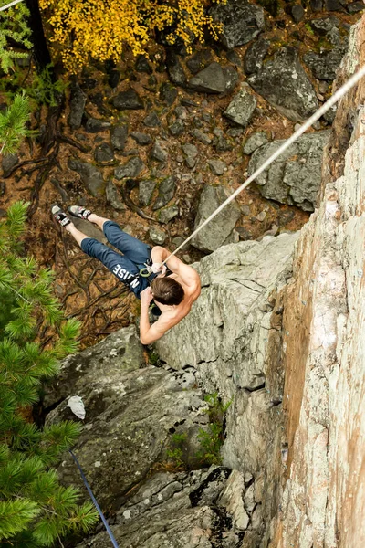 Rock climber coming down cliff on a rope, top view — Stock Photo, Image