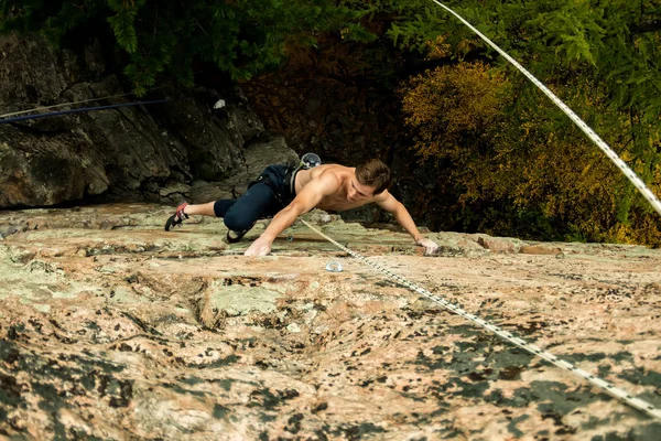 Escalador de roca sube en un acantilado en una cuerda, vista superior —  Fotos de Stock