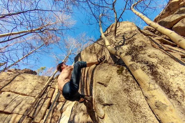 Rock climber climbs a boulder over a rock without insurance — Stock Photo, Image