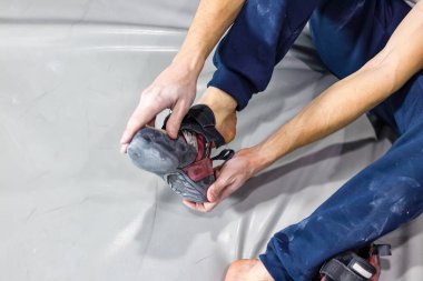 Tırmanma spor salonunda bir bouldering salonda kayalık ayakkabılar kaya tırmanışçısı koyar