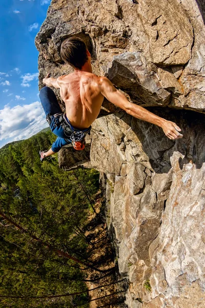 Extremkletterer hängt ohne seilfreies Solo an einem Felsen. vertikales Panorama — Stockfoto