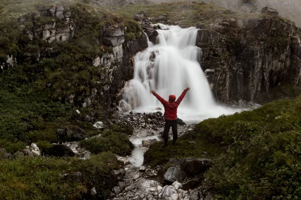 Homem está sob uma cachoeira de montanha no vale nebuloso da Islândia — Fotografia de Stock
