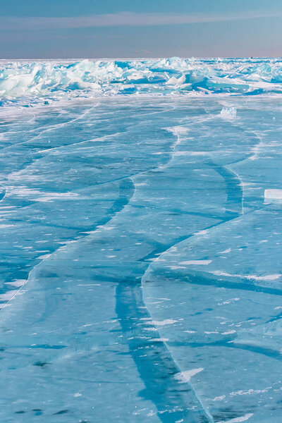 Blue ice of Lake Baikal covered with cracks and hummocks
