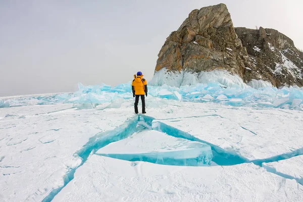 Homme se tient près du cap Khoboy rocher sur l'île Olkhon, lac Baïkal, hummocks de glace en hiver, Russie, Sibérie — Photo