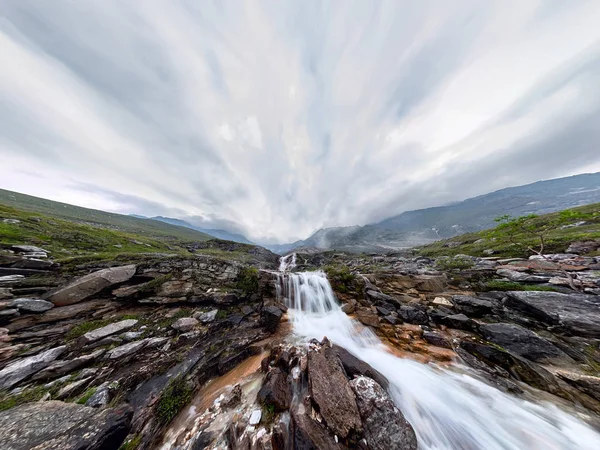 Corrente de cachoeira de montanha em tempo chuvoso nebuloso nas flores do vale — Fotografia de Stock