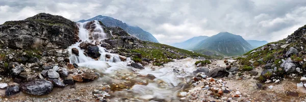 Dağın şelalesi, vadideki çiçeklerin sisli yağmurlu havasında. Silindirik Panorama 360