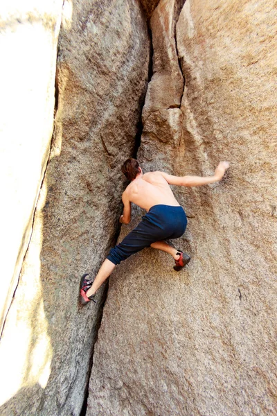 Rock climber climbs a boulder over a rock without insurance — Stock Photo, Image