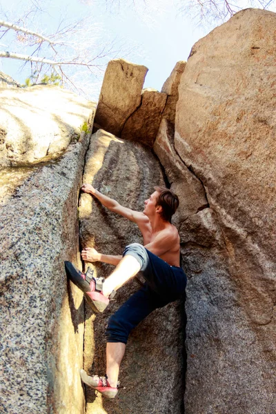 Rock climber climbs a boulder over a rock without insurance — Stock Photo, Image