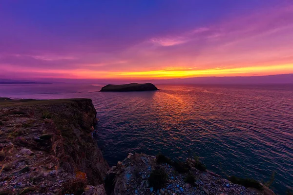 O navio navega em um fundo do céu roxo do por do sol nas ondas do lago Baikal de Olkhon — Fotografia de Stock