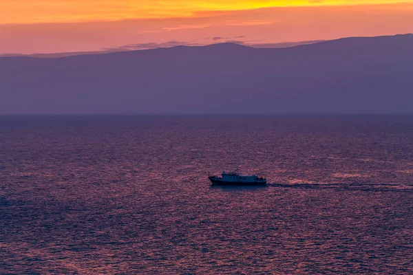 Loď pluje na pozadí purpurového nebe při západu slunce na vlnách jezera Baikal z Olkhonu — Stock fotografie