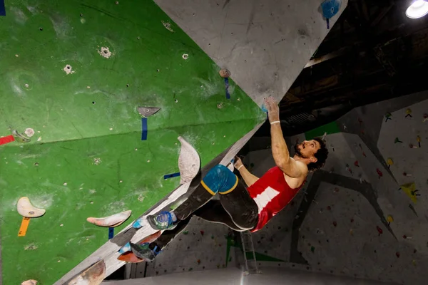 바위 산악인 남자 색된 걸이에 내부 bouldering 등반 벽에 걸려 — 스톡 사진