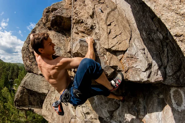 Escalador Extremo sube una roca en una cuerda con el seguro superior, con vistas al bosque — Foto de Stock