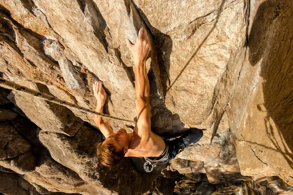 Climber Extreme climbs a rock on a rope with the top insurance, top view from above — Stock Photo, Image