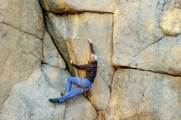 Rock klimmer klimt een rotsblok over een rots zonder verzekering — Stockfoto